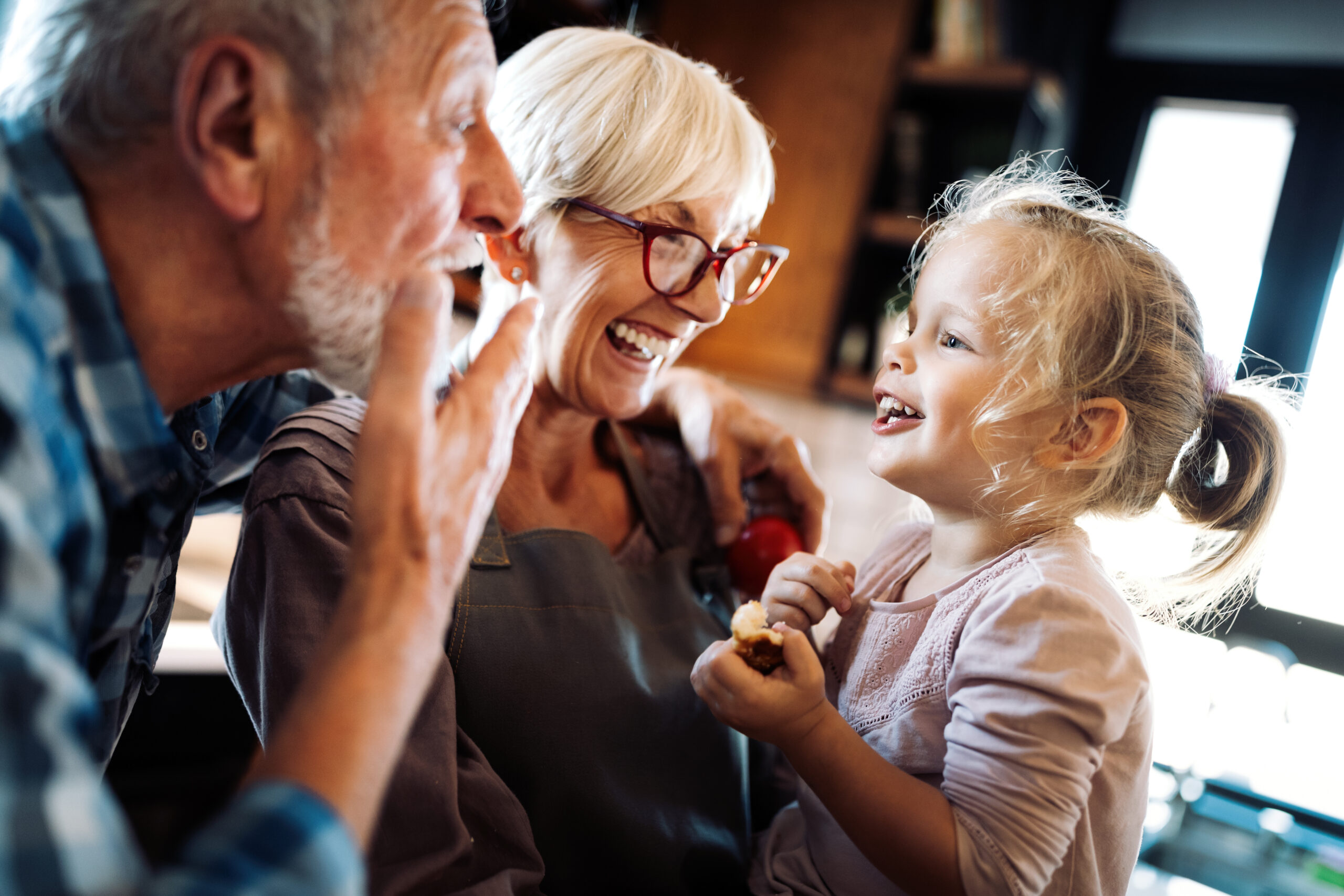 Happy grandparents playing with granddaughter